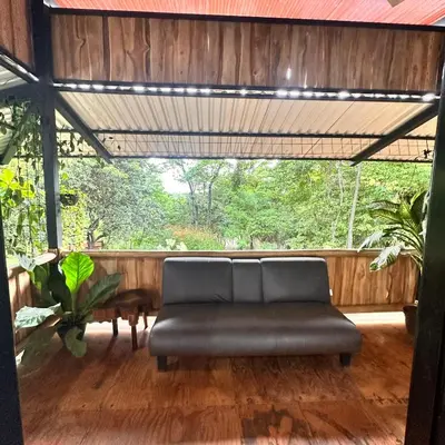 a couch sitting on a porch with a wooden floor at Casa Laurel in Santa Cruz