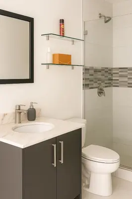 a bathroom with a sink and a toilet and a mirror at Apartamento moderno con vista al río, piscinas y gym Costa Rica in Santa Ana