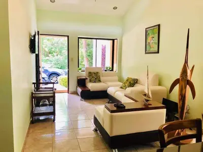 a living room with a couch and a table at Beach House In Punta Leona with private Pool in Punta Leona