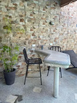 a table and chairs next to a brick wall at Beach House In Punta Leona with private Pool in Punta Leona