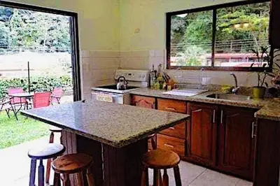 a kitchen with a counter and some stools in it at Beach House In Punta Leona with private Pool in Punta Leona