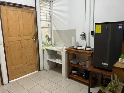 a bathroom with a door and a sink and a television at El Jardín de Tere in Bijagua