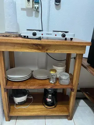 a wooden shelf with plates and dishes on it at El Jardín de Tere in Bijagua