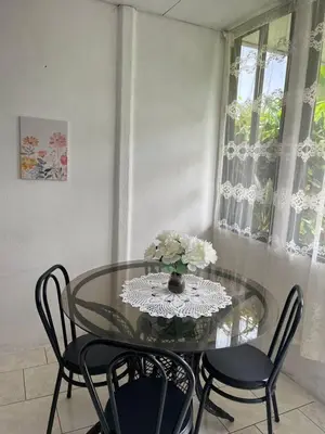 a dining room table with a vase of flowers on it at El Jardín de Tere in Bijagua
