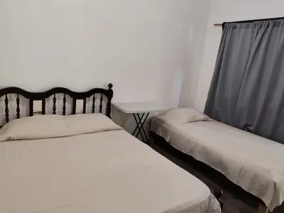 a bedroom with two beds and a side table at Apartamentos el Espavel in Santa Teresa Beach