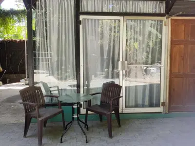 a glass table and chairs in front of a house at Apartamentos el Espavel in Santa Teresa Beach