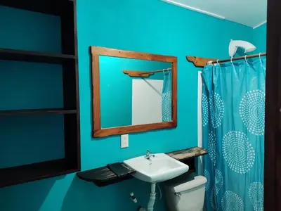 a bathroom with a sink and a mirror and a toilet at Apartamentos el Espavel in Santa Teresa Beach