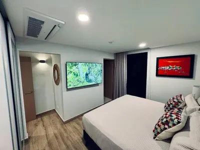 a hotel room with a bed and a couch at Modern Haven with Forest Views and Ocean Breeze in Jacó
