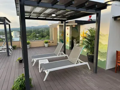 two lounge chairs on a deck on a roof at Modern Haven with Forest Views and Ocean Breeze in Jacó