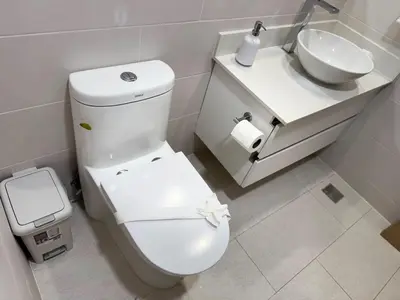 a bathroom with a white toilet and a sink at Modern Haven with Forest Views and Ocean Breeze in Jacó