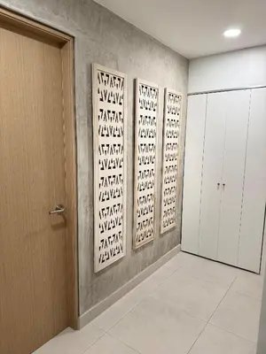 a hallway with three panels ofigraphy on the wall at Modern Haven with Forest Views and Ocean Breeze in Jacó