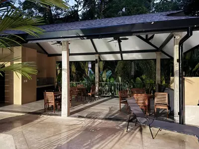 a pavilion with chairs and tables on a patio at Modern Haven with Forest Views and Ocean Breeze in Jacó