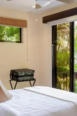 a bedroom with a bed and a table and a window at Casa Mareas in Dominicalito