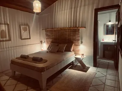 a bedroom with a bed and a mirror and a sink at Nagomi Casita #1 in Sámara