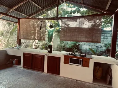 a kitchen with a counter with a sink and a window at Nagomi Casita #1 in Sámara