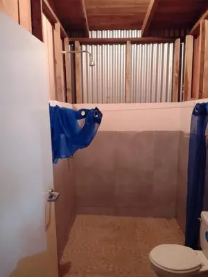 a bathroom with a toilet with a blue object on the door at El Spot Orgánico in Quesada