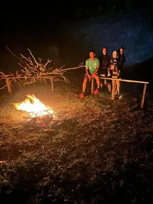 a group of people sitting on a bench next to a fire at El Spot Orgánico in Quesada