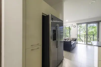 a kitchen with a stainless steel refrigerator and a living room at Corporate Stays Urban Flats Studio in San Rafael
