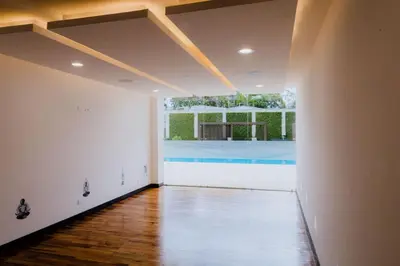 an empty living room with a pool in the background at Corporate Stays Urban Flats Studio in San Rafael