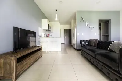 a living room with a black couch and a flat screen tv at Corporate Stays Urban Flats Studio in San Rafael