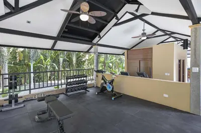 a room with a gym with chairs and a ceiling fan at Brand New Loft Few Steps From The Beach in Jacó