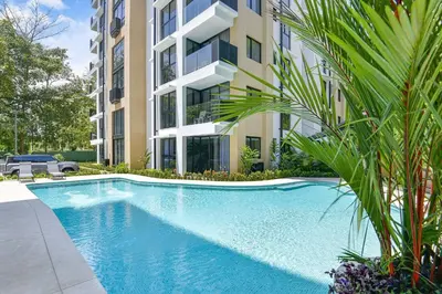 a swimming pool in front of a building at Brand New Loft Few Steps From The Beach in Jacó