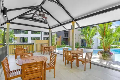 a patio with tables and chairs and a pool at Brand New Loft Few Steps From The Beach in Jacó