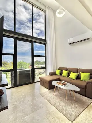 a living room with a couch and a table at Brand New Loft Few Steps From The Beach in Jacó