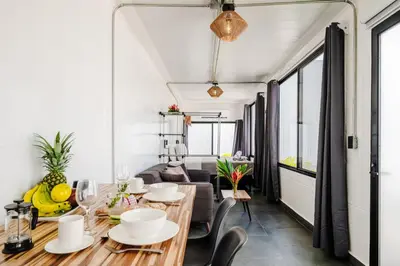 a dining room with a table and chairs and a couch at The DEN in Tamarindo