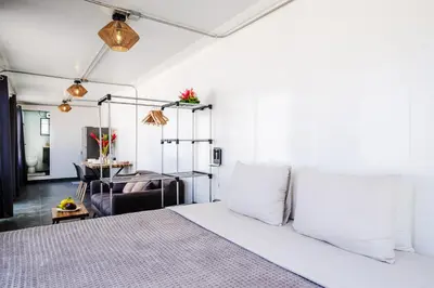 a bedroom with a large bed with white pillows at The DEN in Tamarindo