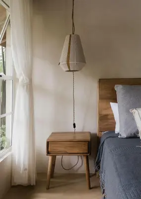 a bedroom with a bed and a table with a lamp at Gorgeous beachfront villa with private pool in Santa Teresa Beach