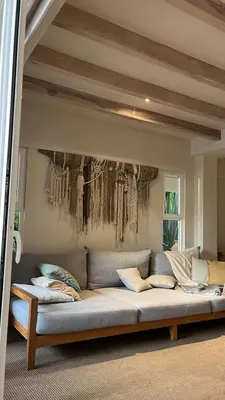 a couch in a room with clothes hanging on the wall at Gorgeous beachfront villa with private pool in Santa Teresa Beach