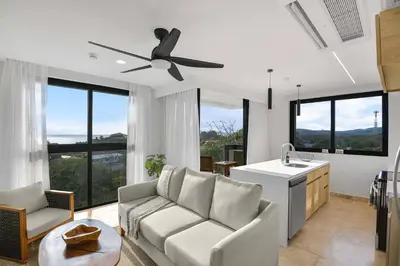 a living room with a couch and a ceiling fan at Heavenly View - 2 BDRM Oceanview Apartment in Jacó