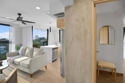 a living room with a couch and a kitchen at Heavenly View - 2 BDRM Oceanview Apartment in Jacó