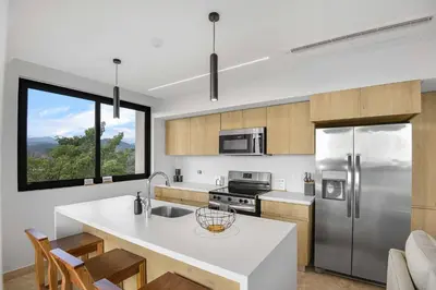 a kitchen with a stainless steel refrigerator and a counter at Heavenly View - 2 BDRM Oceanview Apartment in Jacó