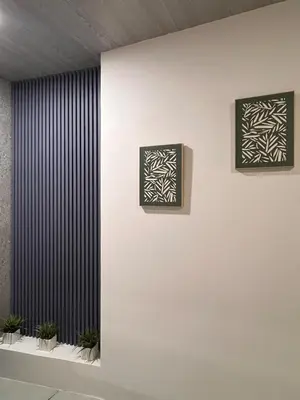 a wall with two pictures on a wall with plants at Kens Lower department in Quepos