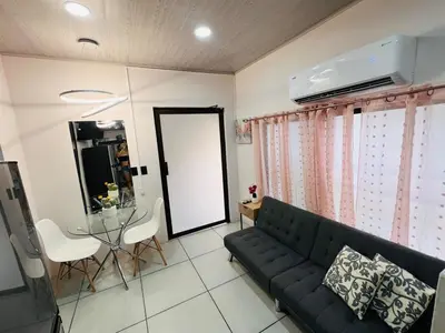 a living room with a couch and a glass table at Kens Lower department in Quepos