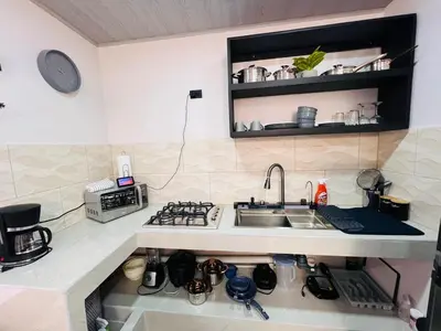 a small kitchen with a sink and a stove at Kens Lower department in Quepos