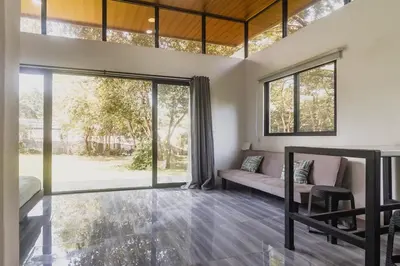 a living room with a couch and large windows at Newly built Surf Hideaway in Avellanas Beach in Playa Avellana