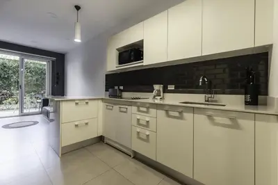 a kitchen with white cabinets and a large window at Corporate Stays Urban Flats 1 Bedroom in San Rafael