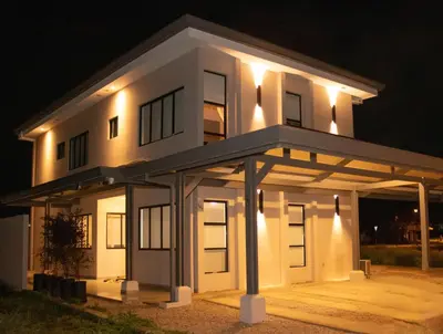 a white house with lights on it at night at Casa PAMPA in Liberia