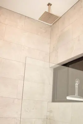 a bathroom with a white tile wall and a window at Casa PAMPA in Liberia