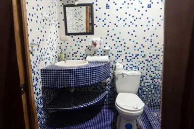 a blue and white bathroom with a toilet and a sink at Poolside Unit at Beachfront Hotel Unit 6 in Sámara