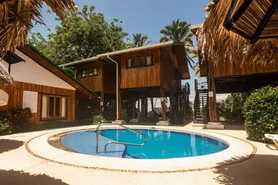 a swimming pool in front of a house at Samara Treehouse Inn Unit 3 in Sámara