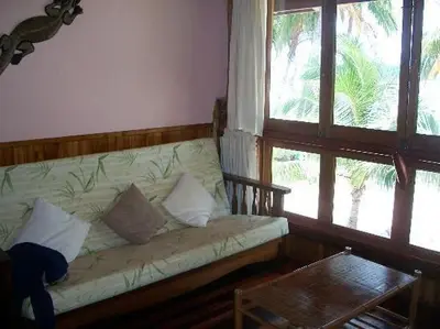 a couch in a room with two windows and a table at Samara Treehouse Inn Unit 3 in Sámara