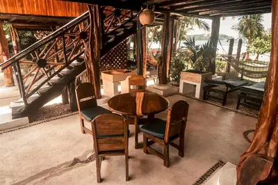 a wooden table and chairs in a room with a balcony at Samara Tree House Inn Unit 4 in Sámara