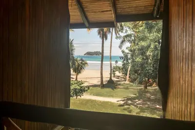 a window view of the beach from a resort at Treehouse Inn on the Beach in Sámara