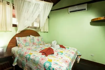 a bedroom with a bed with a stuffed animal on it at Treehouse Inn on the Beach in Sámara