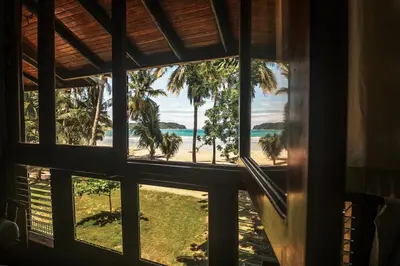 a window view of the beach from a house at Treehouse Inn on the Beach in Sámara