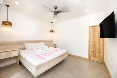 a bedroom with a bed and a flat screen tv at Casa Peace with salt water pool 4BR 4BR in Tamarindo